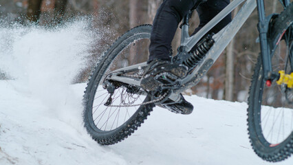 CLOSE UP: Adrenaline winter mountain bike riding on snow-covered forest trail