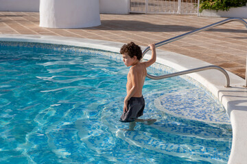 Naklejka premium Child playing in residential swimming pool