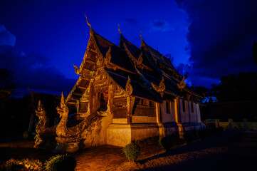 Obraz premium Wat Ton Kwen Intharawat, old wooden Thai Lanna style buddhist temple at night
