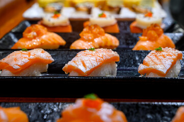 salmon sushi on black plate sale in street food market