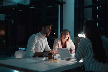 Partner, people and laptop in office at night with documents for deadline or overtime as...