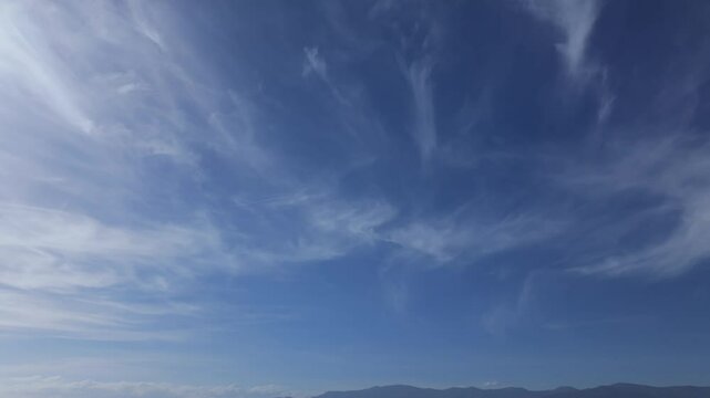 flight with a drone filming the blue sky with a type of clouds called cirrus clouds, we observe them with a turn from left to right on a sunny day