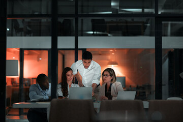 Collaboration, laptop and business people in office at night with stock market charts for corporate...