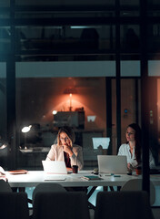 Night, glass and business women with laptop in office for thinking, collaboration and creative solution. Working late, research and website design team with pc for online, planning or problem solving
