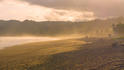 Rain cloud rolling over beautiful beach at Playa Venao in golden sunset light