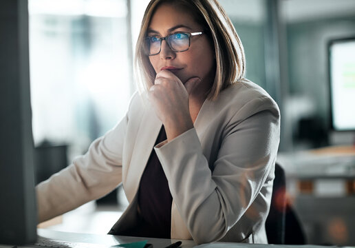 Computer, thinking and business woman reading email, planning or research in office. Idea, decision and internet for information, problem solving or financial consultant working on project solution