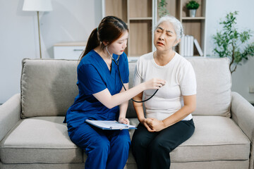 Asian caregiver doctor examine older patient woman therapist nurse at nursing home taking care of...