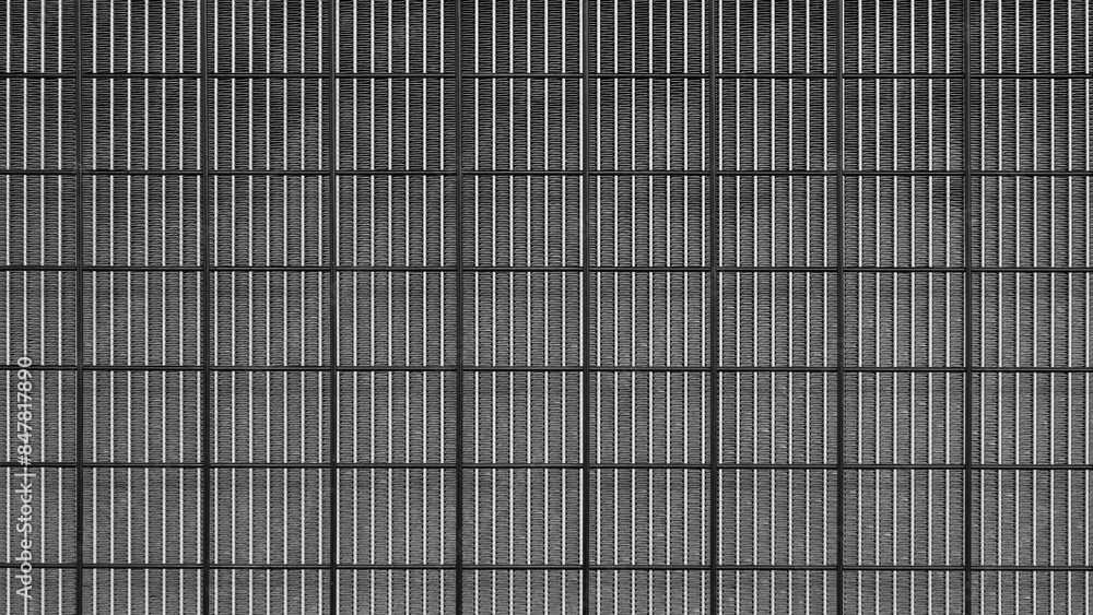 Poster a black and white photo of a wall with a grid pattern. the photo has a moody and somewhat eerie feel
