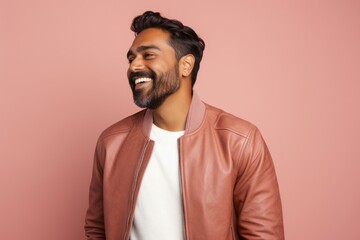 Obraz premium Portrait of a merry indian man in his 30s wearing a trendy bomber jacket over pastel or soft colors background