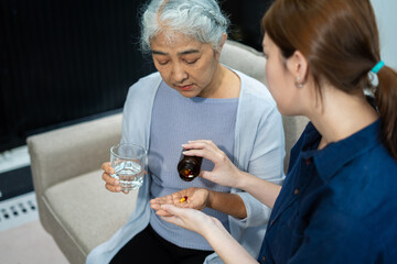 granddaughter taking care and giving a glass of water and taken daily medicine or vitamin supplements, elderly healthcare.
