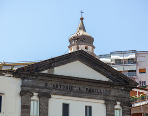 Sant'antonio a posillipo church showcasing stone facade and dome with cross against a clear blue sky in naples, italy