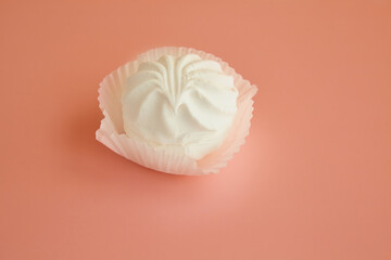 Dessert white marshmallow on a pink background, white marshmallow in a paper tart on a pink table.