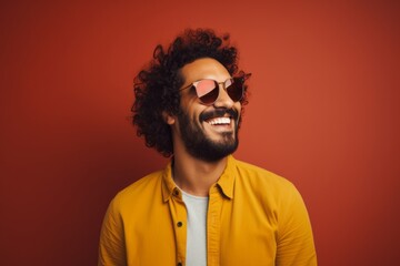 Fototapeta premium Portrait of a joyful man in his 30s wearing a trendy sunglasses in minimalist or empty room background
