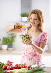 The final preparation of a healthy salad and at the end the smilling cute young woman pours olive...