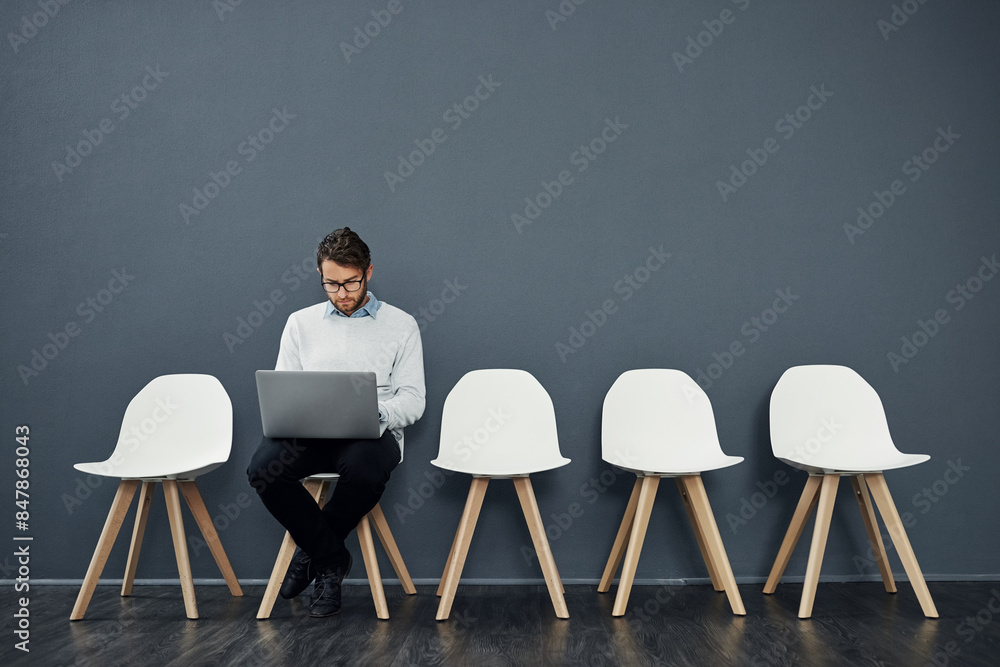 Canvas Prints Business man, computer and waiting room of job search, opportunity or planning for interview or recruitment. Information technology candidate or worker reading on laptop and chair by wall background