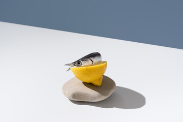 Una anchoa cruda fresca sobre una rodaja de limón y fondo azul	