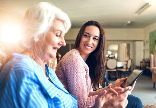 Senior woman, daughter and tablet on sofa for streaming, internet and video call in home living room. Elderly person, child and smile on couch with helping hand for tech savvy, app or communication - Powered by Adobe