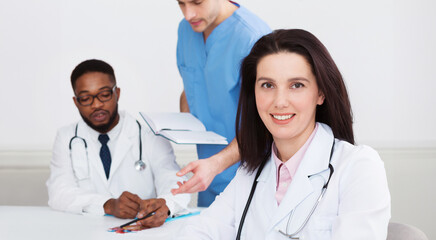 Female Doctor At Conference Holding Medical Report, Looking At Camera