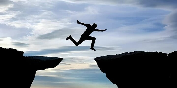 The silhouette of a man jumping from one cliff to another, symbolizes life challenges and personal growth, overcoming obstacles and achieving success