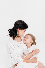 Close-up of a touching and gentle mother and daughter on a light background. Mom's tender touch. Family concept.