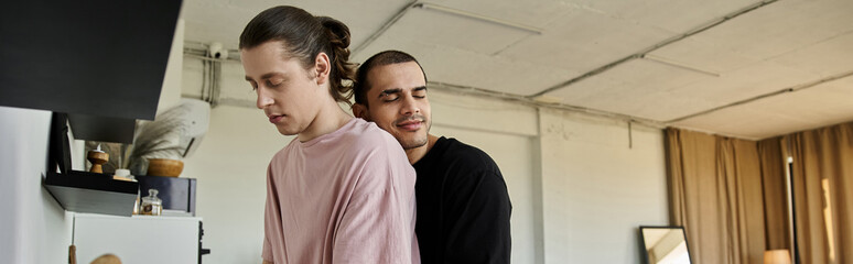 Obraz premium A young gay couple shares a tender moment in their modern home, their connection evident in their embrace.