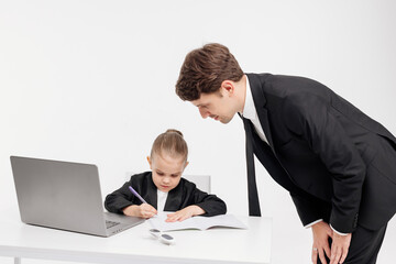 Close-up of a stylish business girl child studying at a laptop on an isolated white background. The...