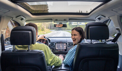 Man and woman traveling in car, sitting in car driving to travel destination.