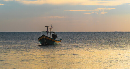 lonely fishing boat in the middle of the sea at sunset