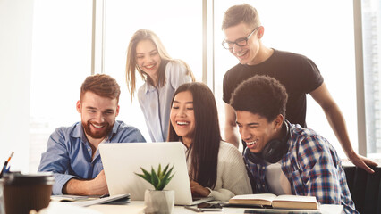 Exams preparation. Multiracial students preparing for exams in library, using laptop together