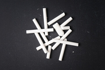 Few pieces of chalk close up on blackboard