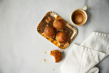 Pardulas on golden plate and espresso coffee on white table. Pardulas are Italian sweets typical...