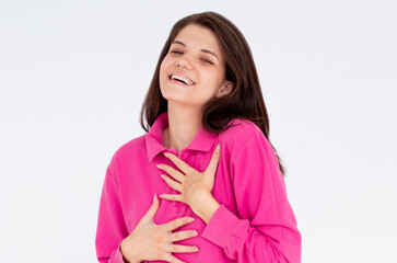 Hilarious joke. Portrait of happy optimistic girl with long hair in pink long sleeve holding belly and laughing out loud, amused by silly funny anecdote