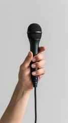 Person holding a microphone against a white background