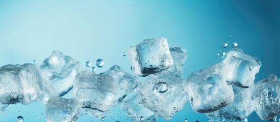 Ice cubes are scattered with water drops scattered on a blue background. Creative banner. Copyspace image