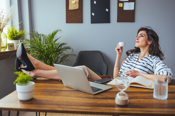 A reflective business professional, feet propped up, savors a coffee break in an office setting,...