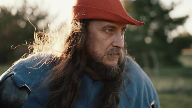 Medieval man in red hat on nature