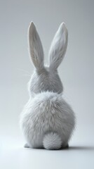 Obraz premium A white rabbit with soft fur and long ears sits with its back to the camera