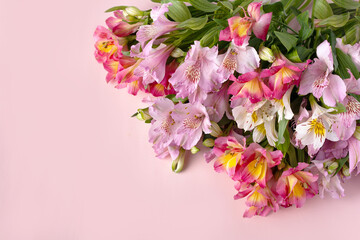 bouquet of wildflowers on a pink background, a copy of space