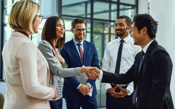 Team, business people and shaking hands for welcome, introduction or greeting in office. Handshake, smile and group with deal for collaboration, agreement or thank you for b2b partnership opportunity