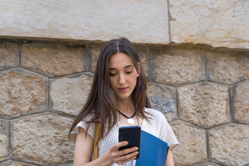 Young College Girl with Backpack Checking Her Phone