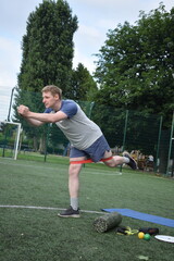 A young man in sportswear engages in a workout, using a sport tool for physical exercises on a...