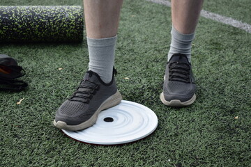 A young man in sportswear engages in a workout, using a sport tool for physical exercises on a...