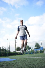 A young man in sportswear engages in a workout, using a sport tool for physical exercises on a...