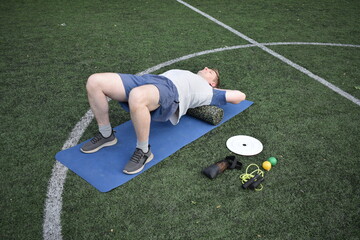 A young man in sportswear engages in a workout, using a sport tool for physical exercises on a...