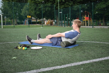 A young man in sportswear engages in a workout, using a sport tool for physical exercises on a...