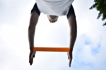 A young man in sportswear engages in a workout, using a sport tool for physical exercises on a...