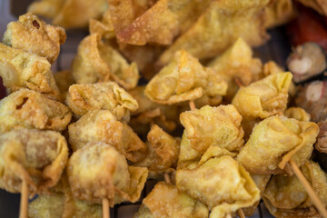 Fried minced pork dumplings on skewers are made from a mixture of wheat flour and other food ingredients, make in various shapes and fried, usually sold on the side of the road at Thailand