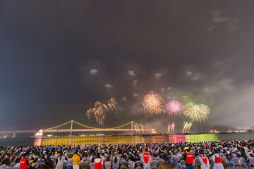 Dazzling fireworks illuminate Busan's night sky, with Gwangan Bridge silhouetted in the background.