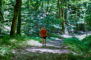 Fototapeta premium a strong middle-aged man running through the forest