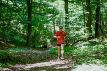 Obraz premium a strong middle-aged man running through the forest